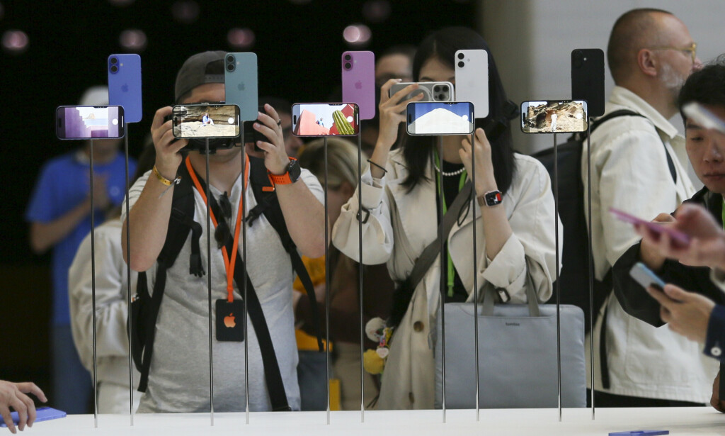 Attendees take a closer look at the Apple iPhone 16 during an announcement of new products at Apple headquarters Monday, Sept. 9, 2024, in Cupertino, Calif. (AP Photo/Juliana Yamada)